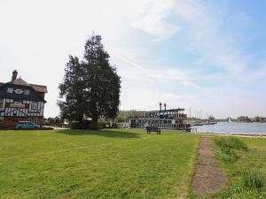 een boot op het water naast een gebouw bij Paws-A-While in Norwich