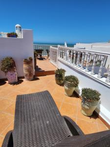 a patio with a bench and potted plants on a balcony at Dar Adul in Essaouira