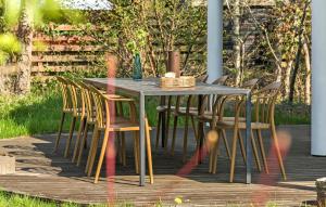a wooden table and chairs on a patio at 4 Bedroom Pet Friendly Home In Strandby in Strandby +12 photos