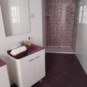 La salle de bains blanche est pourvue d'un lavabo et d'une douche. dans l'établissement Plaza de Chinchón. Apartamento., à Chinchón