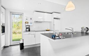 a white kitchen with white cabinets and a sink at Amazing Home In Lgstr With Kitchen in Trend