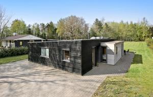 una casa gris y negra con patio trasero en Amazing Home In Lgstr With Kitchen, en Trend