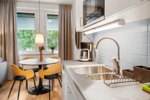 a kitchen with a sink and a table at Liseberg Södra in Gothenburg