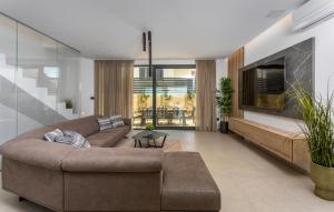 a living room with a couch and a tv at Villa Punat Hills With Pool 1 in Punat