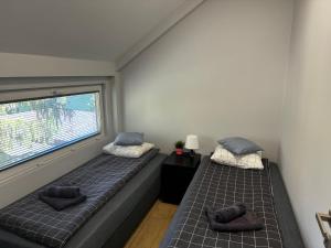 two beds in a small room with a window at Klimatyzowane Apartamenty przy Targach Kielce, Trade Fair in Kielce