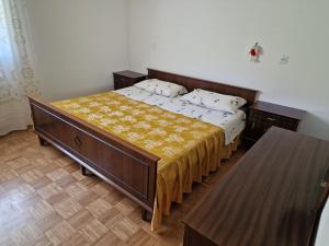 a bedroom with a large bed with a yellow blanket at Apartment Luka at Soča & Koritnica confluence in Bovec