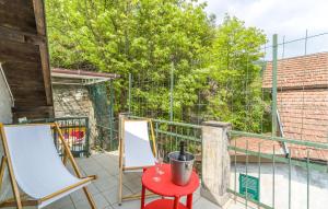 balcone con tavolo rosso e 2 sedie di Casa Elvira a Savignone