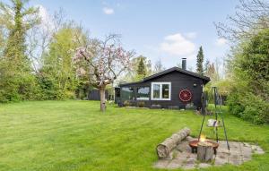 a black tiny house in a yard with a fire hydrant at Lovely Home In Jgerspris With Kitchen in Jægerspris