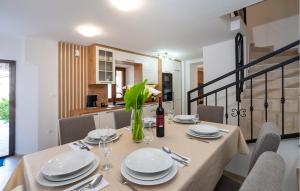a dining room table with plates and a bottle of wine at Lovely Home In Slivnica With Wifi in Slivnica