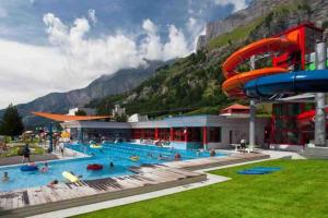 a large swimming pool with a water slide at DOMINO - Superbe studio de standing in Leukerbad