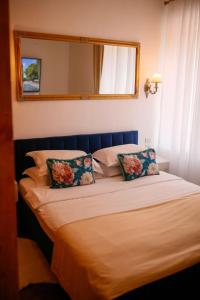 - un lit avec 2 oreillers et un miroir dans l'établissement Joseph Hayn Apartments, à Sighişoara