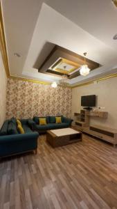 ein Wohnzimmer mit einem Sofa und einem TV in der Unterkunft شقه مفروشه احد رفيدة in Ad Darb