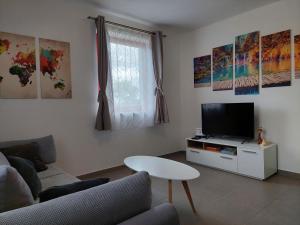 a living room with a couch and a tv at Sleepy Paradise Plitvice in Rakovica