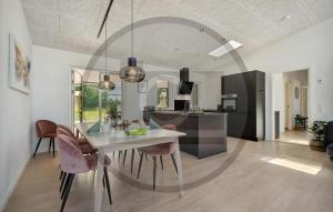 cocina y comedor con mesa y sillas en Beautiful Home In Brkop With Sauna en Børkop