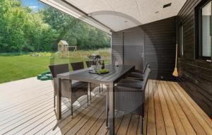 um pátio com uma mesa e cadeiras num deque em Beautiful Home In Brkop With Sauna em Børkop
