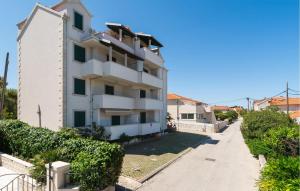 un immeuble d'appartements blanc avec un trottoir devant lui dans l'établissement Gorgeous Apartment In Supetar With Wifi, à Supetar 11 autres photos