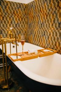 a bath tub with a glass of wine on it at Joseph Hayn Apartments in Sighişoara