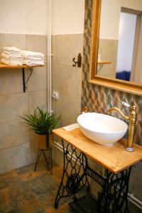 La salle de bains est pourvue d'un lavabo blanc et d'un miroir. dans l'établissement Joseph Hayn Apartments, à Sighişoara