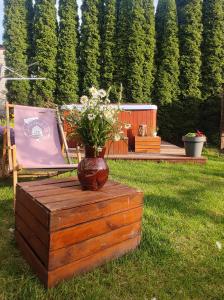 un jarrón de flores sentado sobre una mesa de madera en Lawendowo- sauna jacuzzi domki w ogrodzie i apartamenty w kamienicy, en Sandomierz