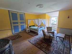 sypialnia z łóżkiem i pokój z żółtymi ścianami w obiekcie Chambres de tour rustique dans la vallée des Pyrénées au Chateau Montegut w mieście Montégut