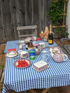 una mesa azul y blanca con platos de comida y una botella de vino en Ferienwohnung Hofen 5 en Peiting