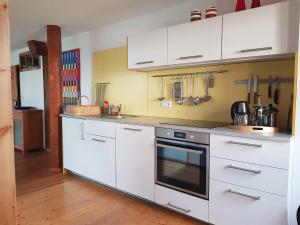 a kitchen with white cabinets and a stove top oven at Ferienwohnung Hofen 5 in Peiting