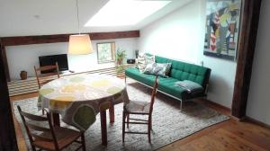ein Wohnzimmer mit einem grünen Sofa und einem Tisch in der Unterkunft Ferienwohnung Hofen 5 in Peiting