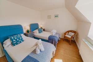 a small bedroom with two beds and a chair at Dairyman's Cottage At Tapnell Farm in Yarmouth +19 photos