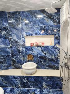 Baño de azulejos azules con un bol en un estante en Strandhaus direkt am Meer en Mezitli