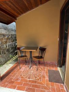 uma mesa e duas cadeiras num pátio em Chalé 08 com hidro no coração de Penedo em Itatiaia