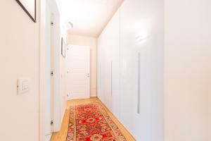 a hallway with a red rug on a floor at Chic Elegance at Borgo Tommasini Apartment in Parma