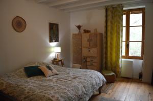 una camera da letto con un letto, un comò e una finestra di La Fabrique du Ronçon a Saint-Bonnet-le-Troncy