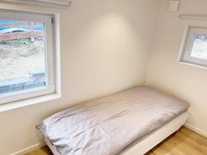 łóżko w pokoju z oknem w obiekcie Newly built Attefall house located in Tumba just outside Stockholm w mieście Tumba