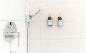 a shower with two bottles on a white tiled wall at 90 qm barrierefreies Apartment I Altstadt I Parkplatz in Quedlinburg +16 photos