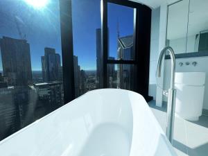 a white bathroom with a view of a city at Beautiful 4B3B CBD Melbourne apartment Free WIFI in Melbourne +21 photos