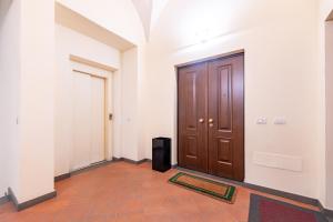 a hallway with a wooden door and a rug at Chic Elegance at Borgo Tommasini Apartment in Parma
