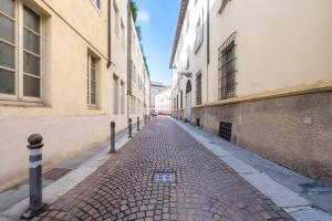a cobblestone street in an alley between two buildings at Chic Elegance at Borgo Tommasini Apartment in Parma