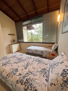 two beds in a room with a window at Pariká Pousada in Alto Paraíso de Goiás