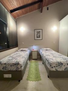 een slaapkamer met 2 bedden en een groen tapijt bij Pariká Pousada in Alto Paraíso de Goiás