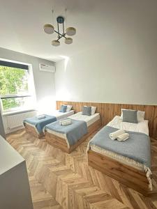 - une chambre avec 3 lits et une fenêtre dans l'établissement Mastersclub, à Ternopil