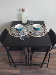 a black table with two plates and wine glasses at studio hyeres port et iles d'or. in Hyères