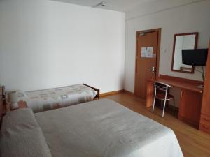 una camera con 2 letti, una scrivania e una TV di Hotel Silva Frontemare a Lido di Jesolo