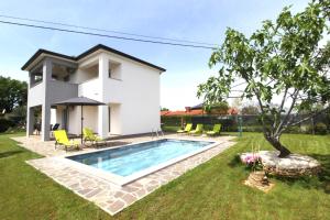 a house with a swimming pool in a yard at Villa MARES in Umag