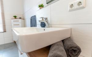 a white bathroom with a sink in a room at Barrierefrei I free parking I Terasse I Netflix in Quedlinburg +15 photos