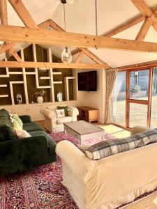a living room with two couches and a table at Oak Grange holiday cottage in Hoxne