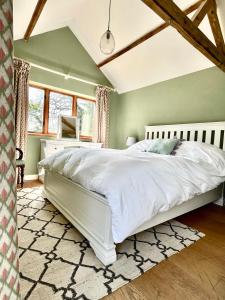 a bedroom with a large white bed in a room at Oak Grange holiday cottage in Hoxne