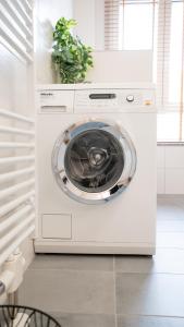 a washer and dryer in a white kitchen at Barrierefrei I free parking I Terasse I Netflix in Quedlinburg