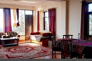 sala de estar con sofá, mesa y ventanas en Sun set retreat, en Shimla