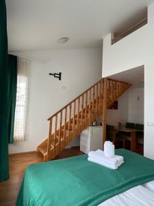 Un dormitorio con una cama verde y una escalera en Media Luna Guesthouse, en Seyðisfjörður