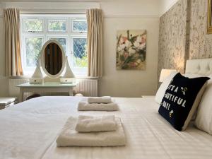 um quarto com uma grande cama branca com duas toalhas em Monte Bre em Ventnor